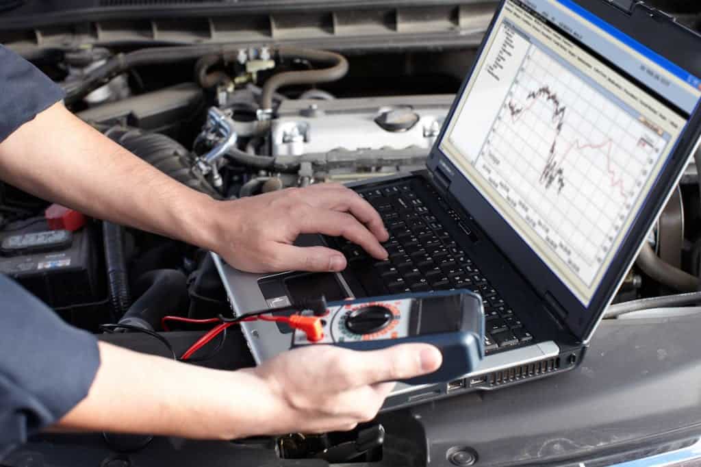 Auto mechanic inspecting engine computer to determine if PCMS needs to be repaired or replaced.