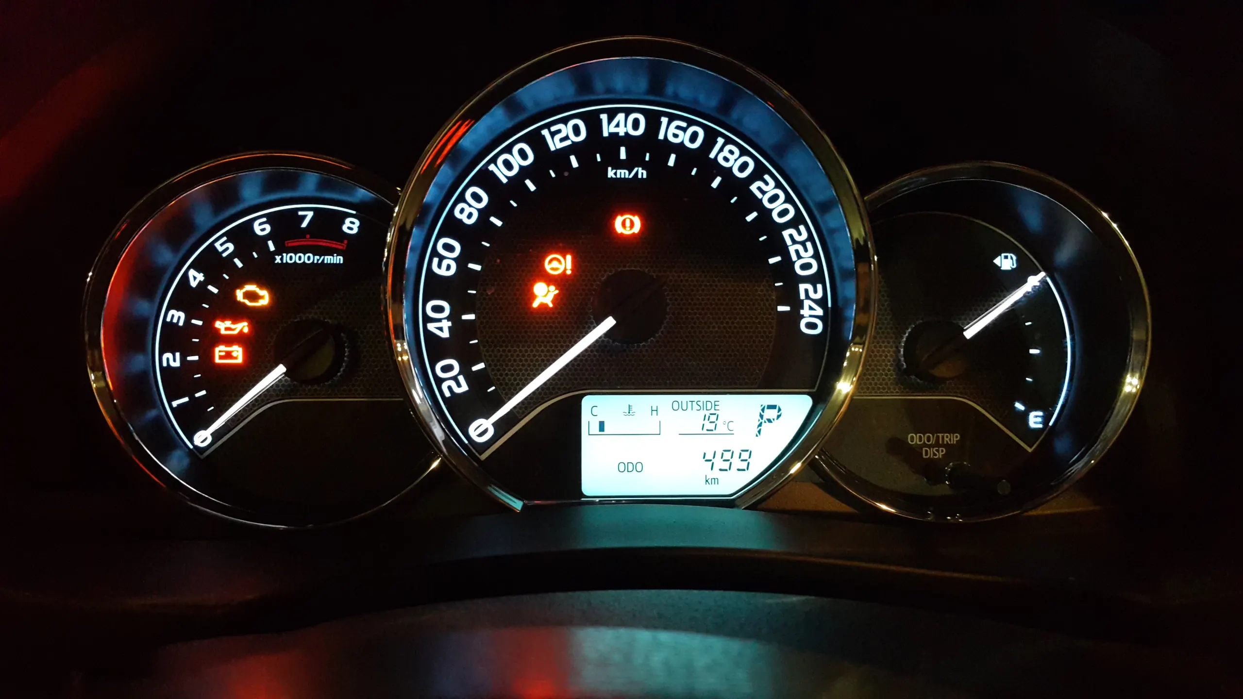An instrument cluster lit with warning lights and a falling fuel gauge