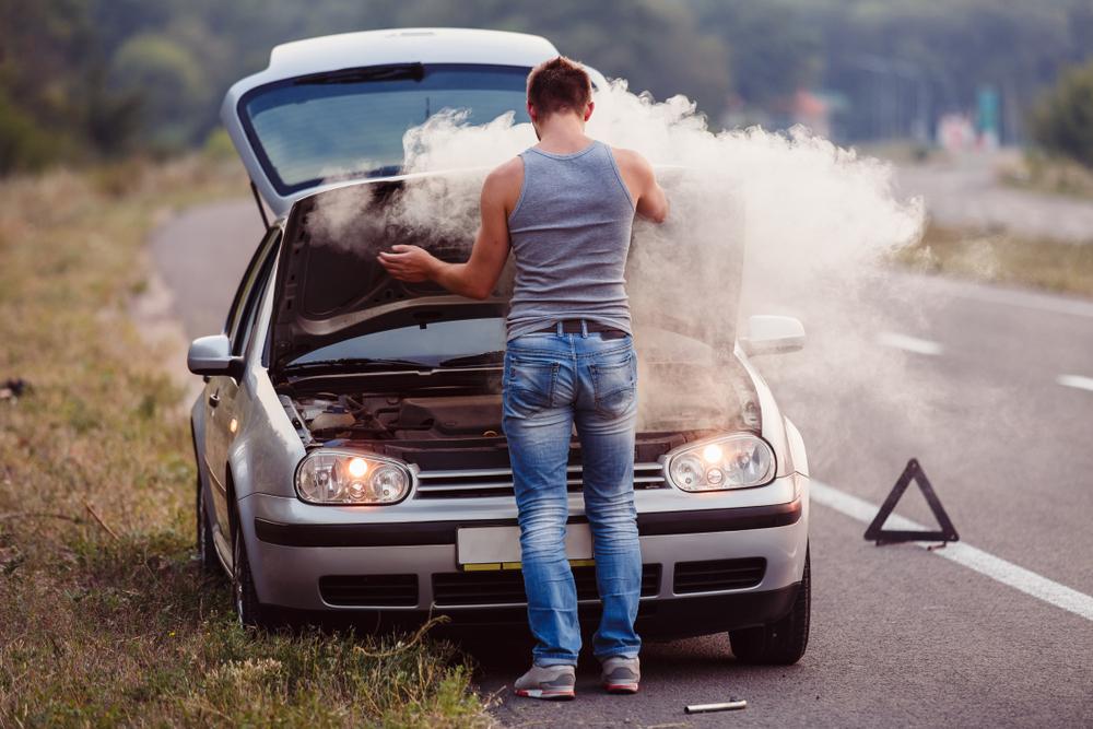 Man lifting his bonnet up with smoke pouring out