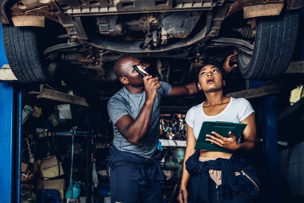 Car mechanic working on computer system repairs for vehicles.