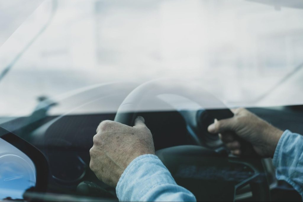 man grabbing steering wheel of toyota u0100