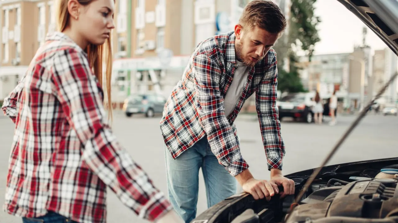 man and woman trying to fix the error code p0174 in their car