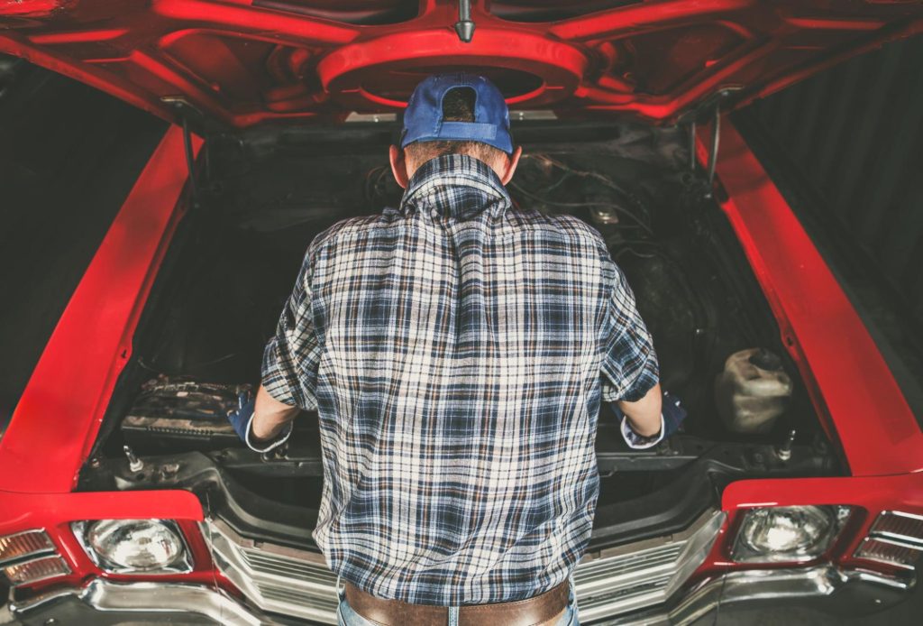 Man doing DIY car computer repair before buying a new ECM