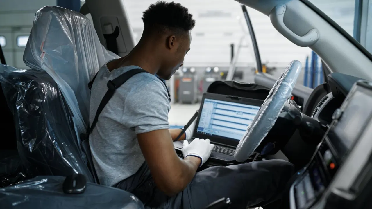 Male mechanic testing new ECM and ECU after buying car