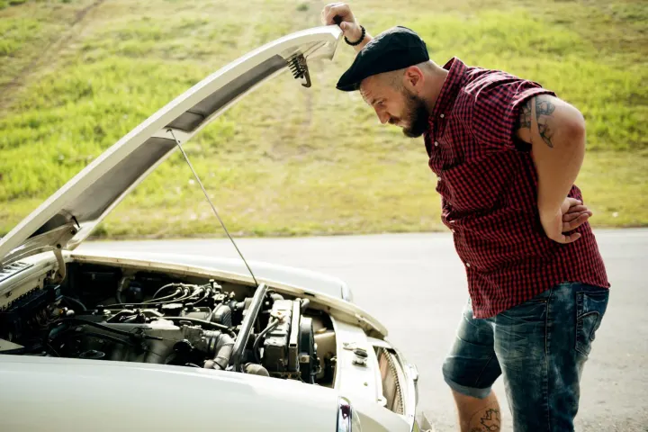 Auto mechanic using tools under the hood to diagnose a vehicle where the OBD has power but no communication.