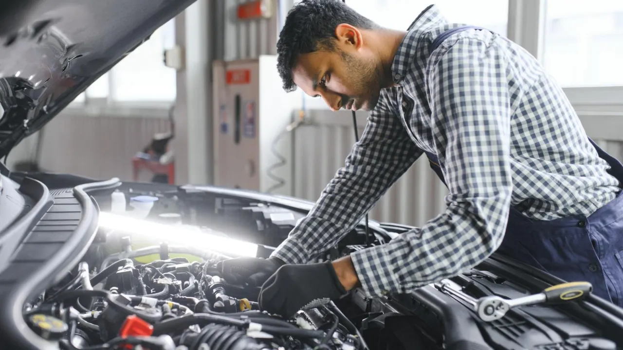 Mechanic using a laptop for OEM-level PCM diagnostics under the hood in a repair bay, where can i get my pcm reprogrammed